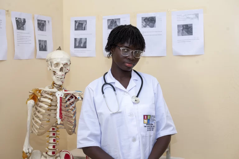 Étudiante avec un stéthoscope à côté d’un squelette pédagogique à IPAF Santé