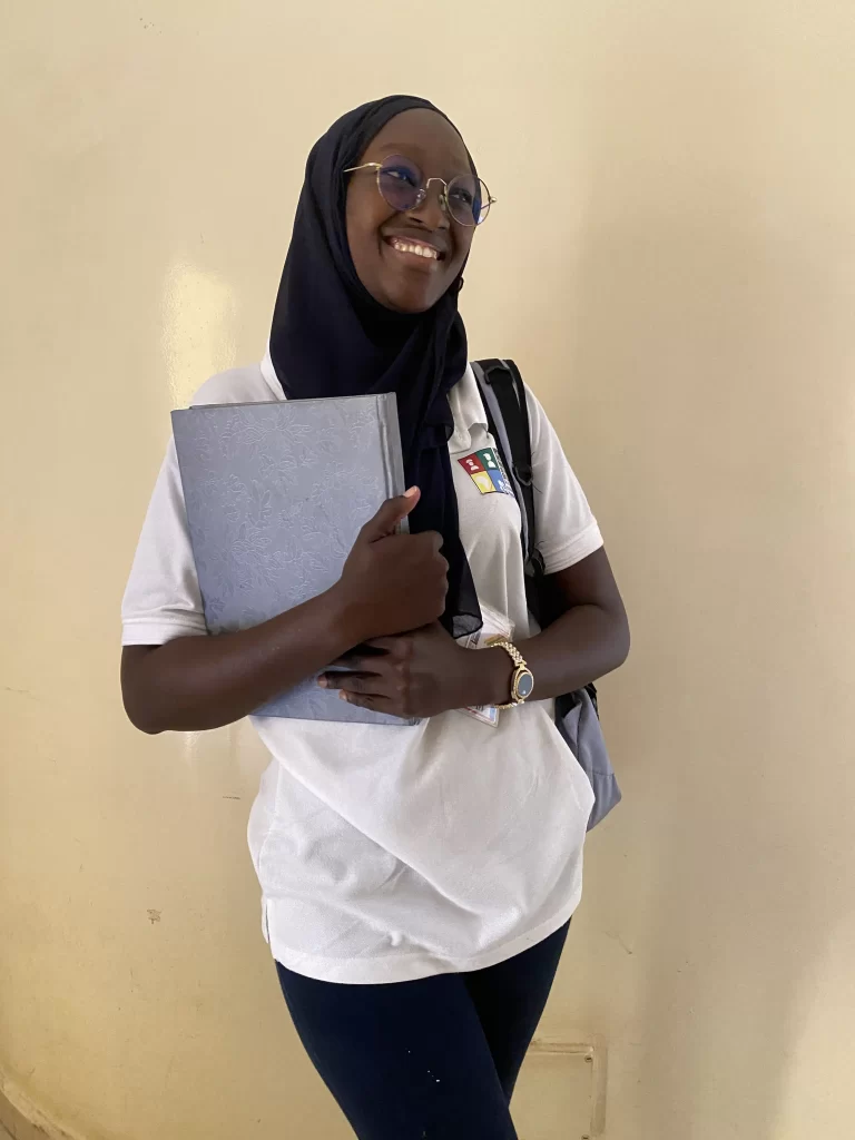 Étudiante en tenue IPAF tenant un classeur