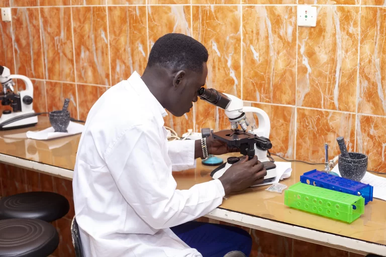 Étudiant observant au microscope dans le laboratoire à IPAF Santé
