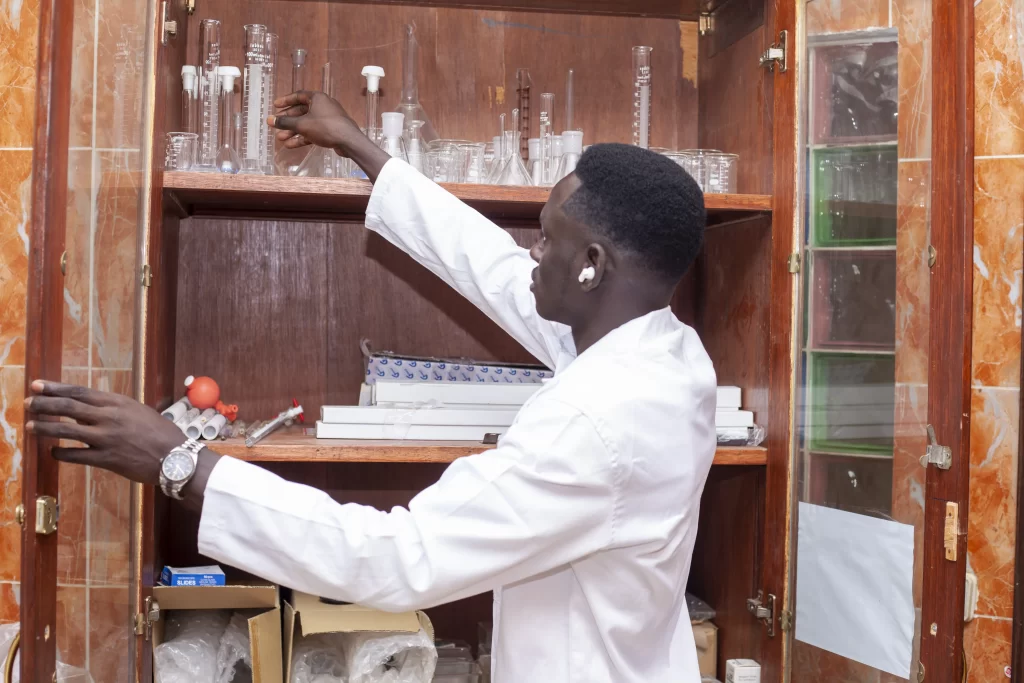 Étudiant en blouse rangeant du matériel de laboratoire à IPAF Santé
